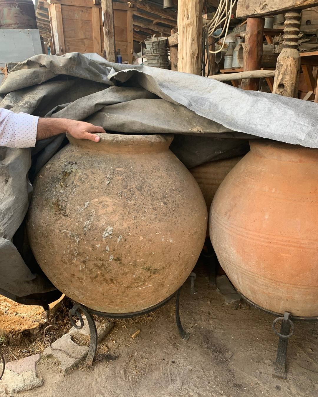 Hand-built terracotta jars being unwrapped in the depot