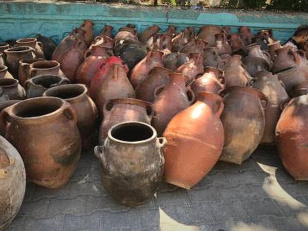 Erzurum Jar, Large — many rust-red two-handled storage jars grouped outdoors on paving