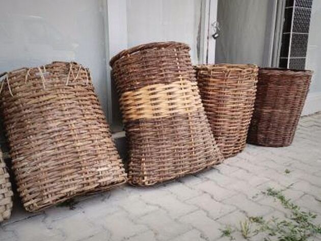 Woven Wicker Basket — woven wicker baskets in brown, one with a pale band, on paving