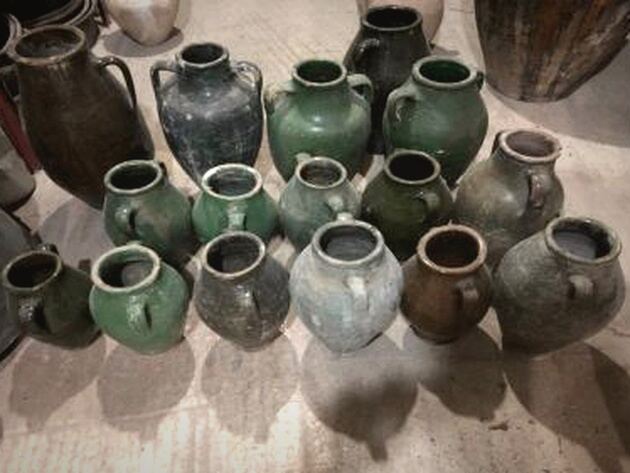 Antep Green Jar — group of green-glazed and dark small jars on a stone floor