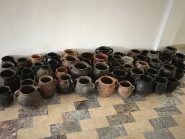 Bayburt-Erzurum Pot, Set II — rows of small black and terracotta handled pots on a tiled floor